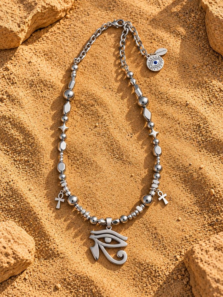 Collana MALOCCHIO «HORUS — SILVER»: perle argentate, piccoli ankh e Occhio di Horus argentato, sulla sabbia